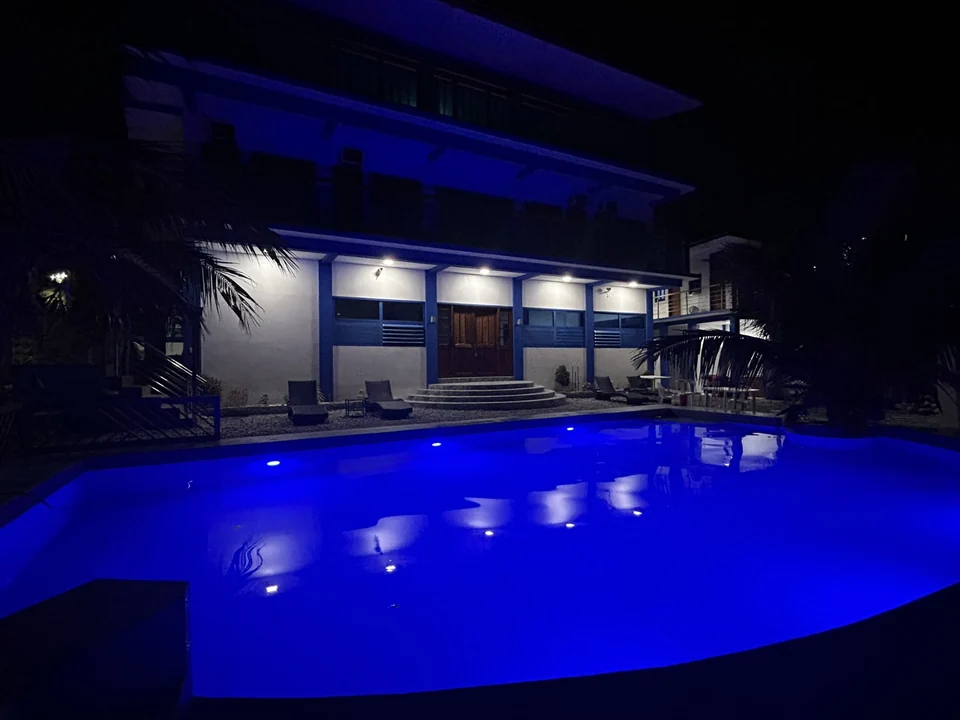 An evening view of the resort swimming pool illuminated in deep blue