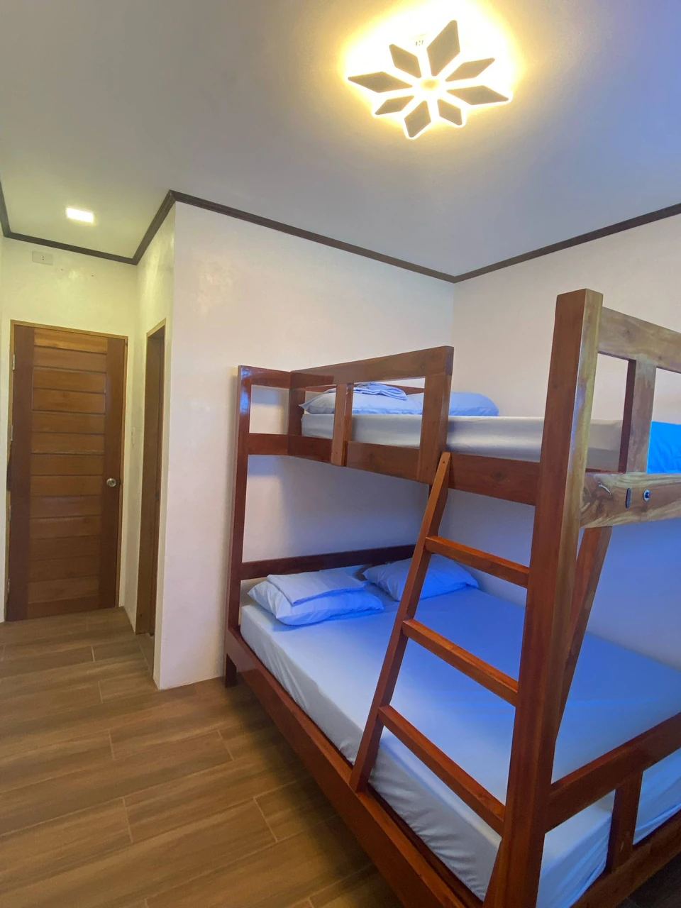 Actual Standard Room with wooden bunk beds and blue bedding